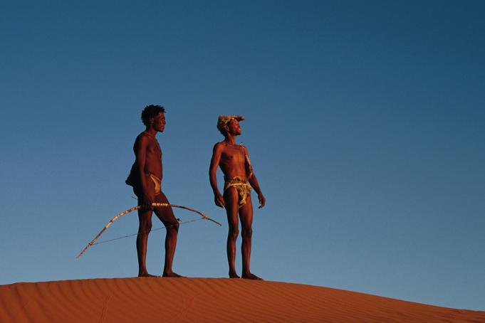 Kalahari Bushmen (San) standing on sand hill.