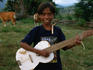 Boy playing home-made guitar in Aidabaleten village.