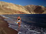 Woman walking along tranquil beach, Tilos.