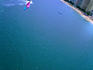 Sandy feet of parasailer and high angle view of city.