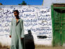 Man in front of wall with Arabic writing.