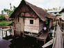 Overhead view of man sitting in doorway of house in a stilt village, northern Sarawak.