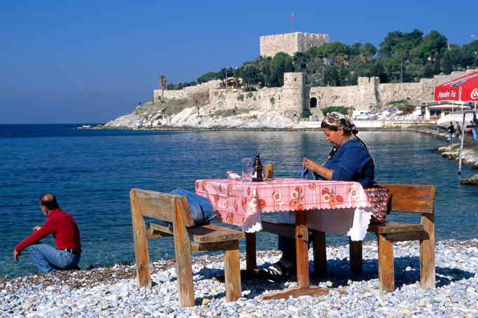 Fisherman's wife knitting on beach in front of the castle (Guvercin Adasi).