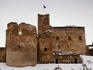 Exterior of ruined castle surrounded by snow.