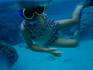 Girl snorkelling while holding onto canoe.