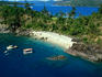 Aerial view of boats and people on a beach.