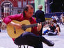 Busker playing guitar on Plaza Mayo, Sol.
