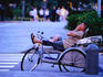 Cyclo driver resting near Raffles Hotel.