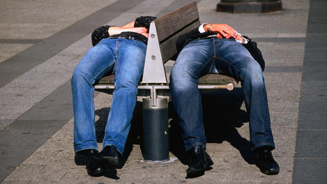 Two men sleeping on bench on Champs-Elysees.