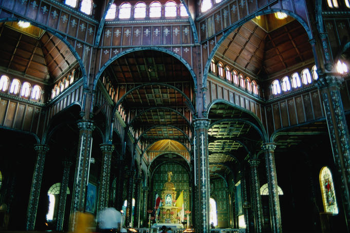 Wood-panelled ceilings and stone columns inside Basilica Cartago.
