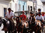 People on horseback and cart returning from pilgrimage.