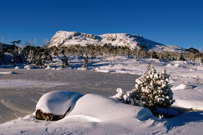 Frozen tarn and King Davids peak under winter snow.