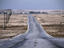 Bitumen road in barren landscape.