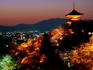 Main hall, sakura trees and pagoda lit up at night at Kiyomizu-dera temple.