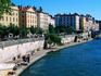 Promenade along Saone River with bridge in distance.