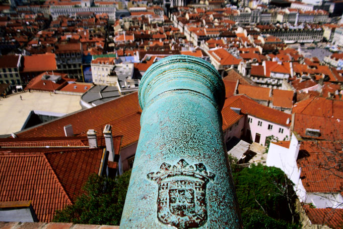 Overhead of city with cannon of Castelo de Sao Jorge in foreground.
