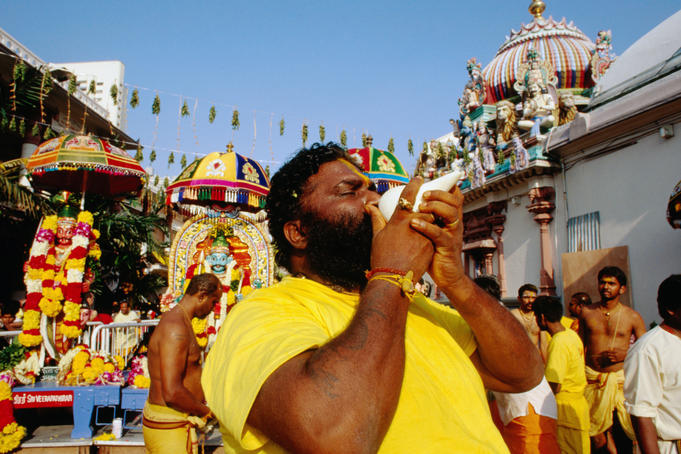 Man blowing a conch at Hindu Deepavali Festival, Sri Mariamman Temple.
