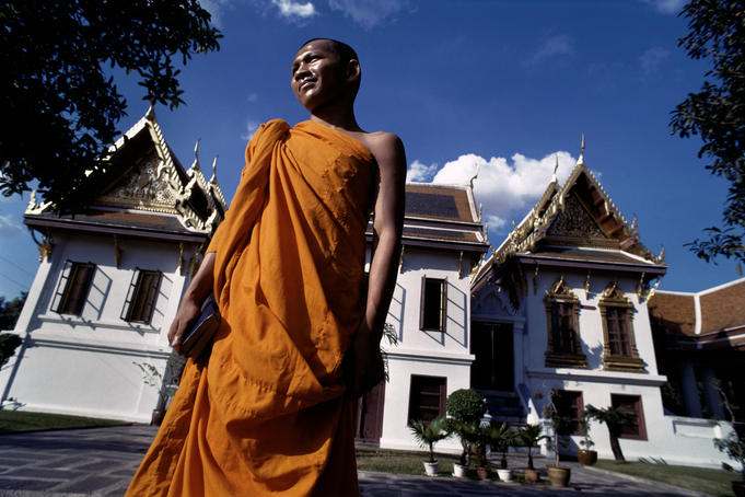 Monk in front of temple, early morning.