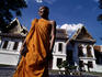Monk in front of temple, early morning.