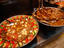 Meat and vegetable dishes on metal plates.
