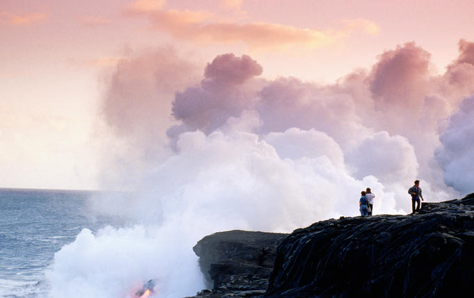 People watching lava flow into ocean.