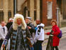 Character actor in historic wig and costume on city street.