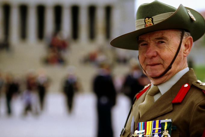 A returned serviceman in uniform showing off his medals outside the Shrine of Remembrance.