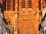 Great rose window of Notre Dame Cathedral's West Front glowing orange in setting sun, Old City.