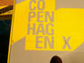 Boy looking at Copenhagen X sign.