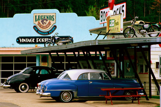Old vehicles outside Boondocks 50s Cafe and Gas Station, Deadwood.