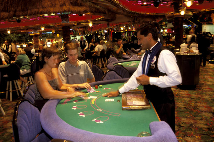Couple at gaming table with dealer.