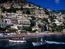 Houses terraced into rugged Amalfi coastline, boats in foreground.