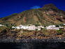 White waterfront houses with volcanic peak behind at Scari.