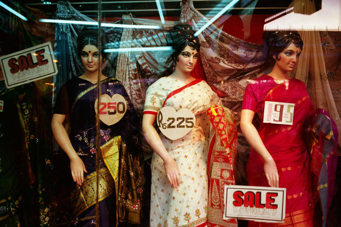 Mannequins in saris in shop window.