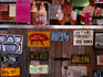 Young woman at the Pig Out Inn, sitting behind a counter full of number plates and signs - Natchez, Mississippi