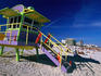 People on beach near colourful lifeguard station, South Beach.