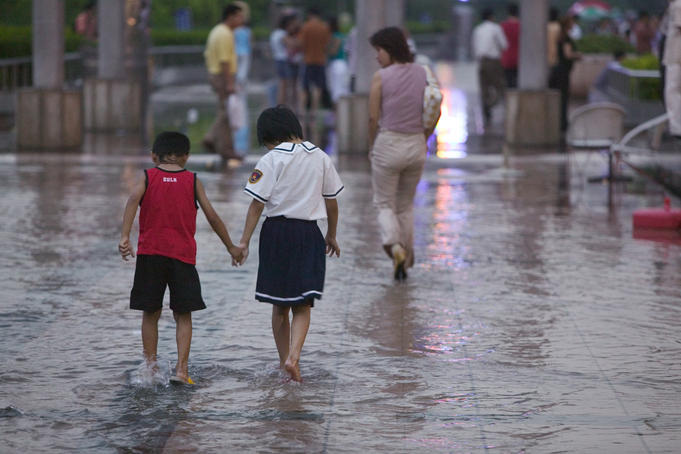Children walking in the water after rain.