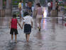 Children walking in the water after rain.