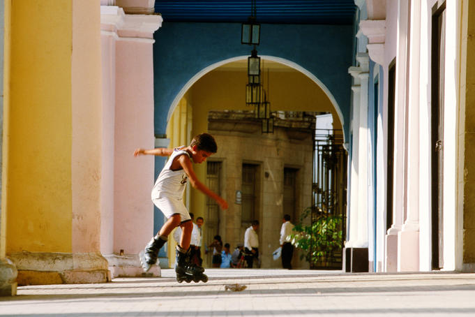 Boy rollerblading in arcade of Plaza Vieja, Habana Vieja.