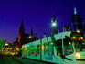 Tram stops for passengers in city at night.