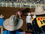 Overhead of bull rider from the stands of a rodeo.