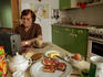Woman listening to news on the radio on her kitchen table.