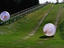"Zorbs" people moving inside balls down a hill.