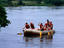 Rafters paddling through rapid-free section on Victoria Nile River.