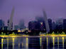 City skyline in fog, with Gateway Arch and Mississippi River.
