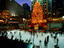 Skaters on rink at Rockefeller Center underneath Christmas tree and statue of Prometheus, Manhattan.