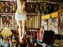 Woman inside Catholic icons shop, with crucifix hanging on wall.