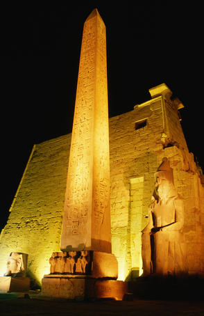 Luxor Temple at night: the light show creates an eerie spectacle as the temple is lit up and the statues and Obelisk are featured - Luxor