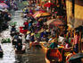 Wooden canoes laden with goods line canal at floating market.