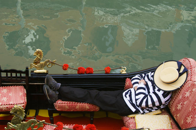 Venice, Italy.  A gondolier takes a break on a slow fall day.  2003